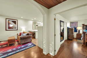 Hallway with wood finished floors, arched walkways, and recessed lighting