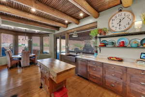 Kitchen featuring a wooden ceiling with exposed beams, light wood-style flooring, plenty of natural light, open shelves, and wooden counters