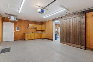 Garage featuring wooden walls and a garage door opener