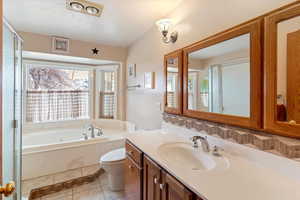 Full bathroom featuring vanity, a garden tub, light tile patterned floors, and a shower with shower door