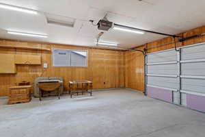 Garage with wooden walls and a garage door opener