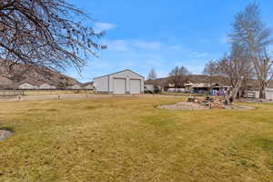 View of yard featuring a garage and an outbuilding