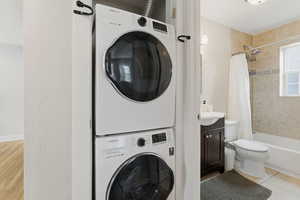 Laundry area featuring stacked washing machine and dryer and light tile patterned floors