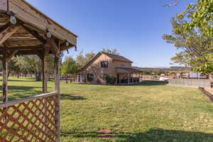 View of grassy yard featuring a patio area and a gazebo