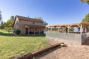 Back of house featuring a patio area, a yard, and a shingled roof