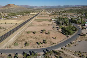 Aerial view of property's location with a mountain backdrop and nearby suburban area
