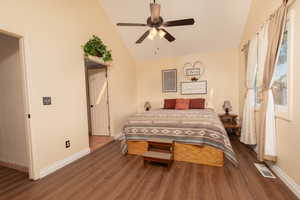 Bedroom with dark wood finished floors, a ceiling fan, and vaulted ceiling
