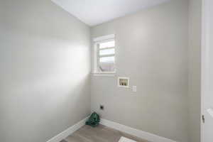 Laundry room featuring hookup for an electric dryer, hookup for a washing machine, and light wood finished floors