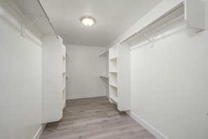 Walk in closet featuring light wood-style floors