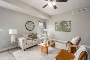 Living area with light wood-style flooring and a ceiling fan