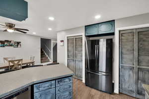 Kitchen featuring stainless steel appliances, light wood finished floors, ceiling fan, recessed lighting, and light stone counters