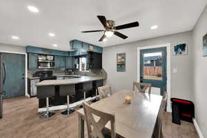 Dining space featuring light wood-style floors, a ceiling fan, and recessed lighting