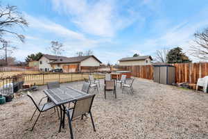 Fenced backyard with a patio, a storage shed, and outdoor dining area