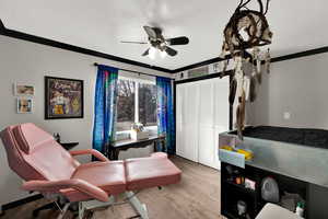 Sitting room featuring crown molding, wood finished floors, ceiling fan, and a textured ceiling