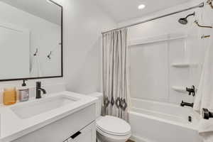 Full bathroom with shower / bathtub combination with curtain, vanity, and recessed lighting