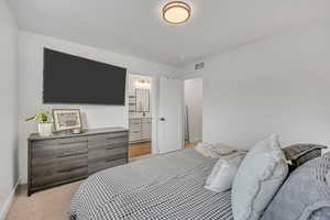 Bedroom with light colored carpet and ensuite bathroom