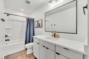 Bathroom featuring shower / bath combo, vanity, light wood-style floors, and recessed lighting