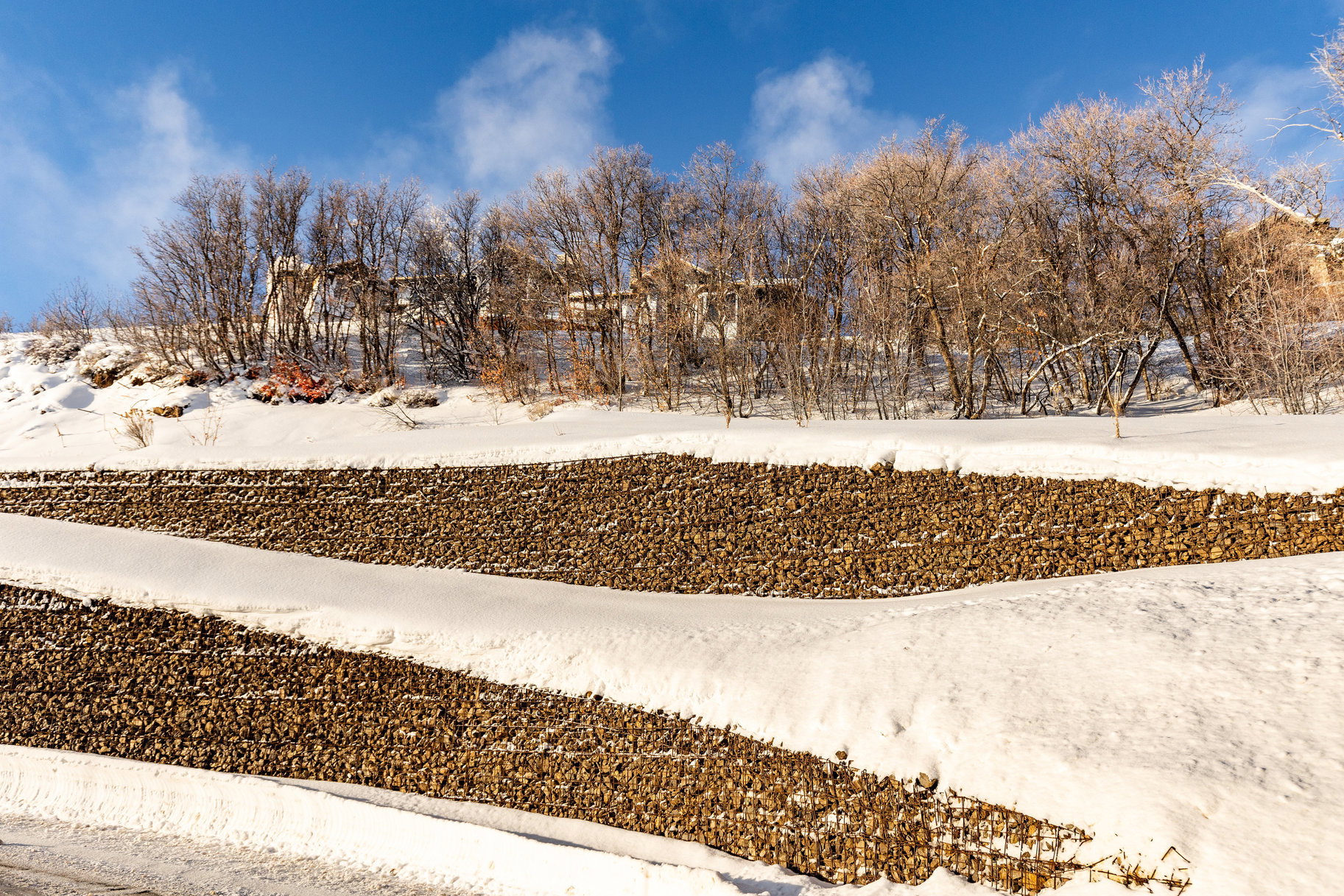 Terraced rock retaining walls featuring winter landscaping