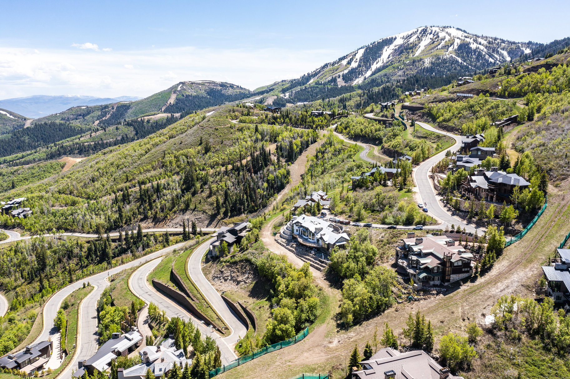 Aerial perspective showcasing a mountain community with winding roads and numerous residences