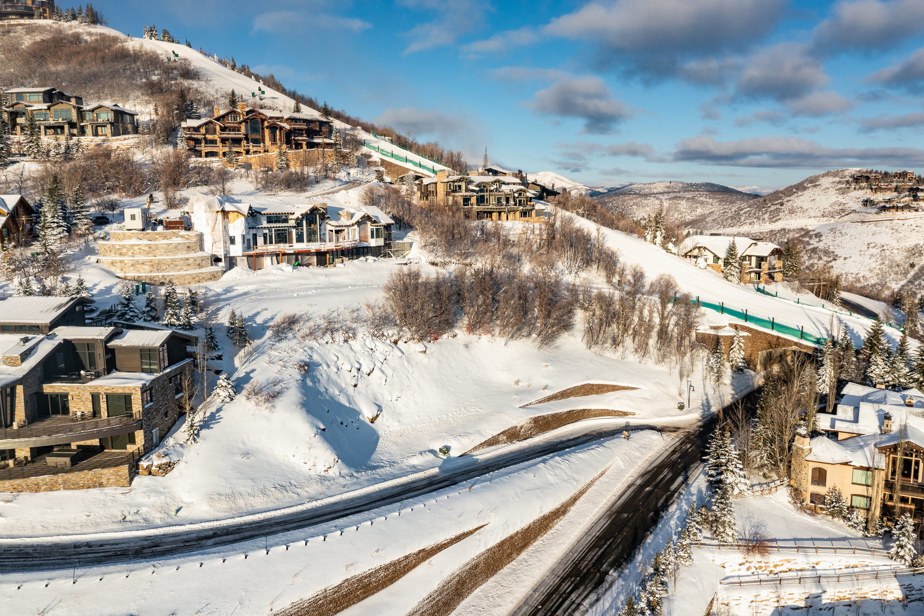 Snow-covered mountain terrain featuring multiple custom residences and a ski run