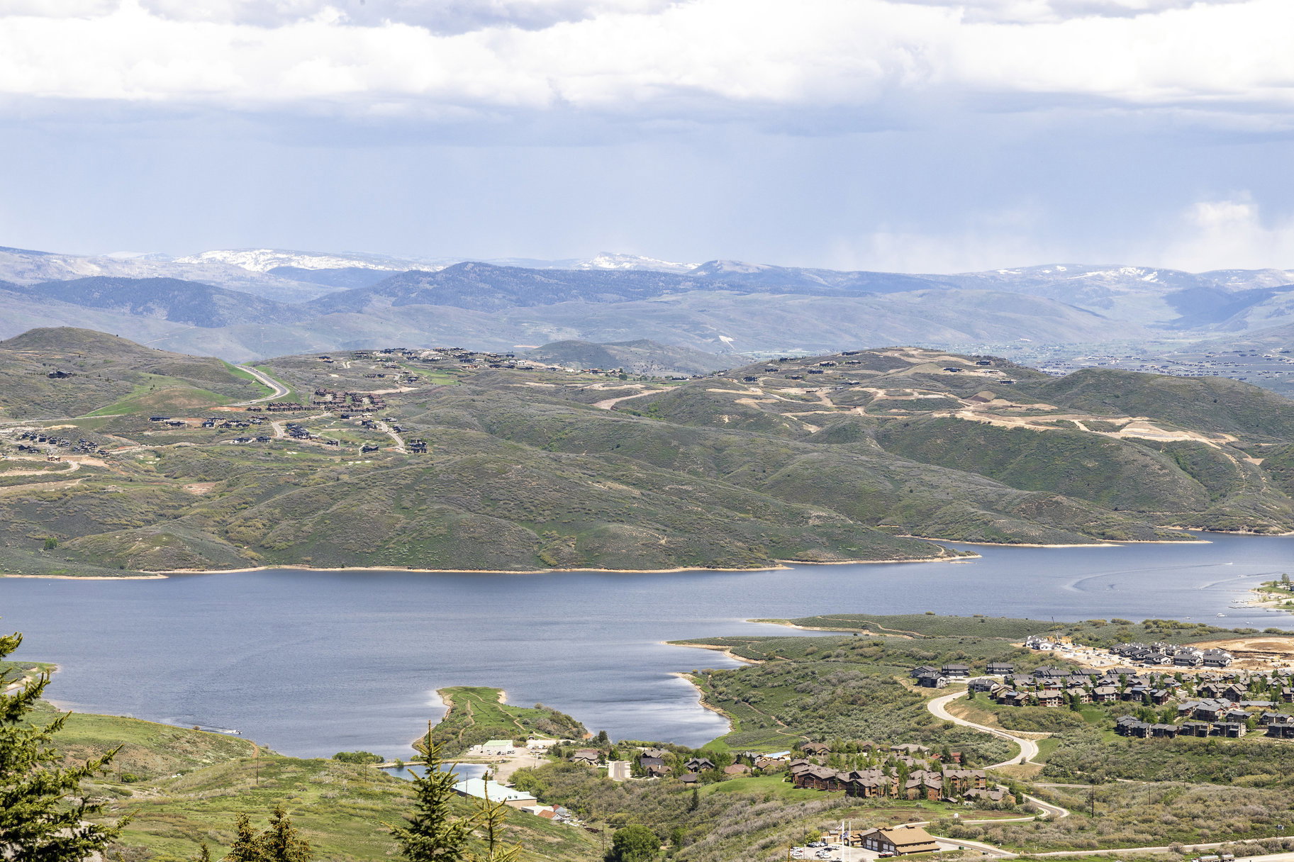 Expansive lake and mountain setting featuring rolling hillsides and residential developments