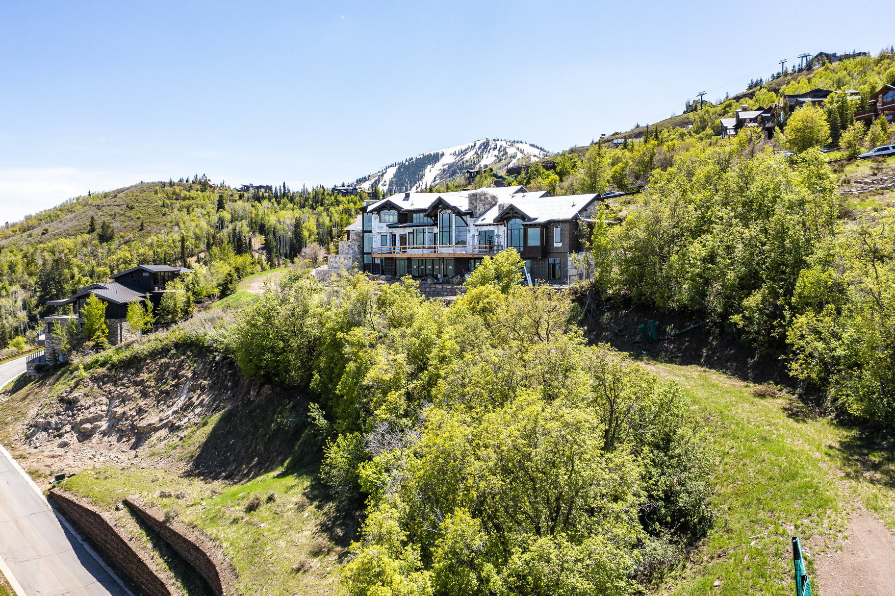 Hillside residence featuring a multi-level design with extensive balconies, stone chimney, and numerous windows