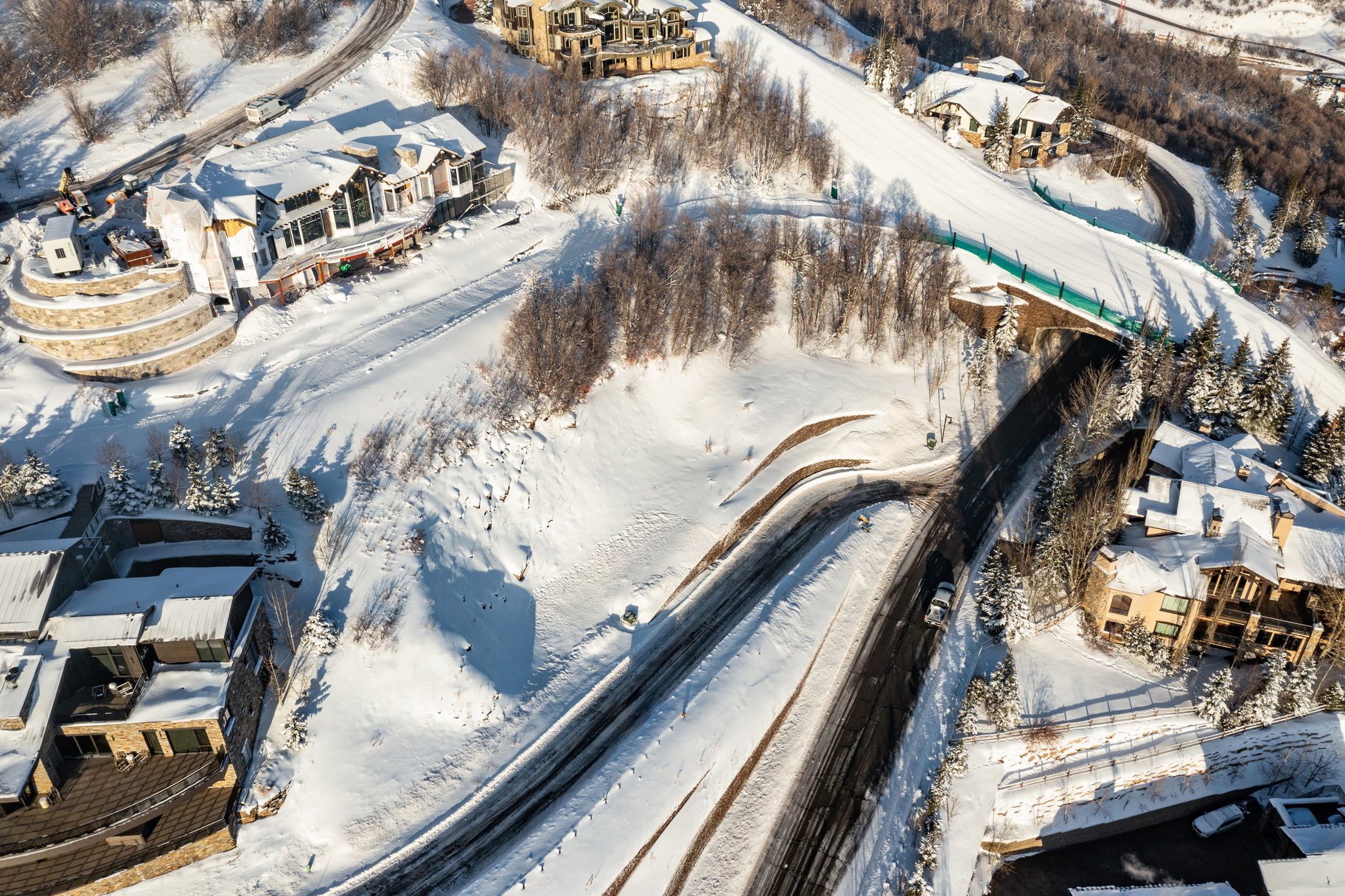Expansive snow-covered landscape featuring multiple residential structures and paved roadways