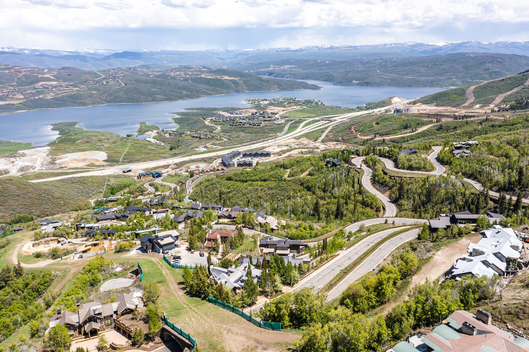 Aerial perspective showcasing rolling hills, a large body of water, and distant mountains