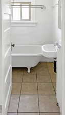 Full bathroom with light tile patterned floors and a sink