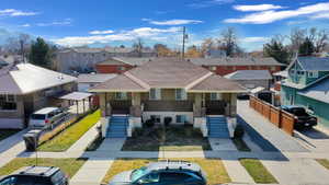 View of front of house featuring brick siding, a residential view, covered porch, and roof with shingles
