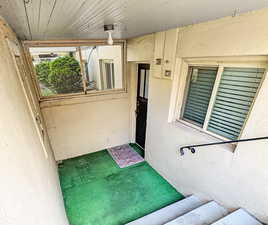 View of exterior entry featuring a sunroom