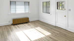 Spare room with radiator and light wood-type flooring