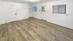 Entrance foyer featuring a textured ceiling and light wood-style floors