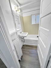 Full bath with wood finished floors, radiator heating unit, and  shower combination