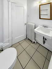 Bathroom featuring radiator and light tile patterned floors