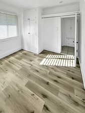 Unfurnished bedroom with a closet and wood finished floors