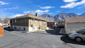 View of side of home with a chimney, brick siding, a mountain view, and a residential view
