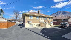 View of front of home with brick siding, a chimney, a residential view, and a mountain view