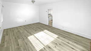 Unfurnished bedroom with light wood-style flooring and baseboards