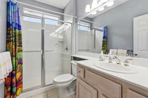 Bathroom featuring vanity, a shower stall, healthy amount of natural light, and light tile patterned floors