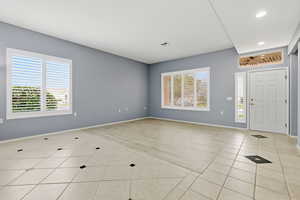 Entryway with light tile patterned floors and baseboards