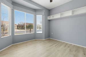 Empty room with light wood-style floors and a ceiling fan