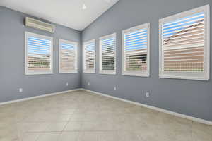 Spare room featuring baseboards and vaulted ceiling