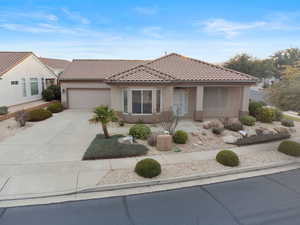 View of front of property featuring stucco siding, concrete driveway, a garage, and a tile roof