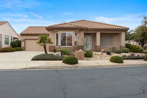 Mediterranean / spanish-style home featuring stucco siding, driveway, an attached garage, and a tile roof