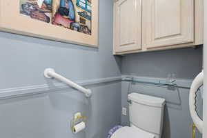 Bathroom featuring toilet and a textured wall