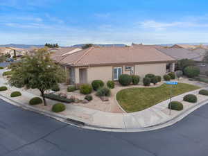 View of front of property with a tiled roof, stucco siding, a front yard, and a residential view