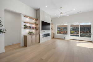 Unfurnished living room with a ceiling fan, light wood finished floors, a large fireplace, and recessed lighting