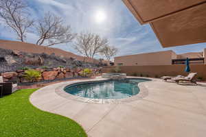 Integrated pool / spa with a fenced backyard and a patio area