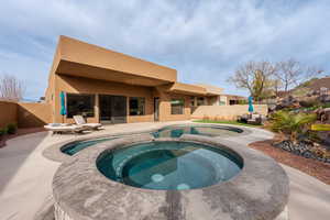 Integrated pool / hot tub with a fenced backyard and a patio area